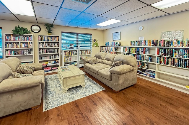 living area featuring a paneled ceiling and hardwood / wood-style floors