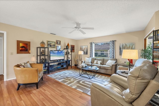 living room featuring a textured ceiling, ceiling fan, and hardwood / wood-style floors