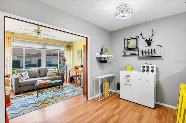 interior space featuring washer / clothes dryer, a textured ceiling, ceiling fan, and hardwood / wood-style floors