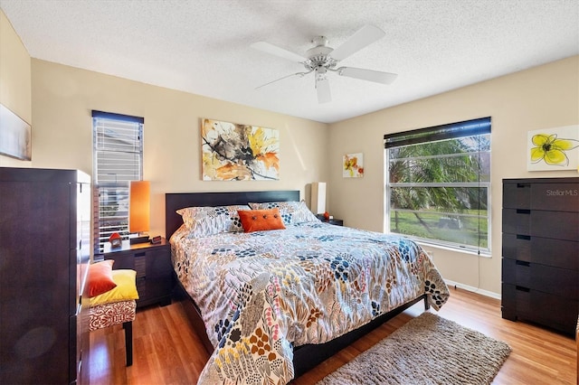 bedroom featuring hardwood / wood-style flooring, a textured ceiling, and ceiling fan