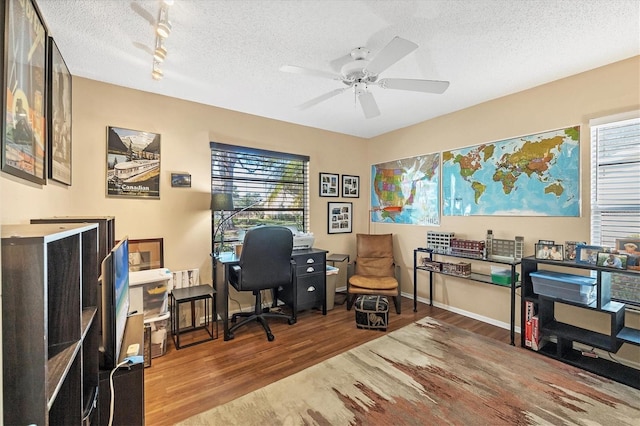 home office featuring ceiling fan, hardwood / wood-style floors, and a textured ceiling