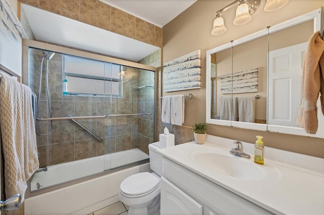 full bathroom with tile patterned flooring, shower / bath combination with glass door, vanity, and toilet