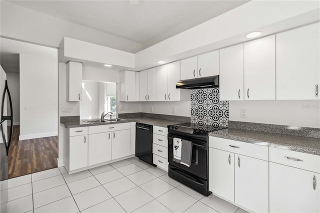 kitchen with black appliances, light tile patterned flooring, white cabinets, and sink