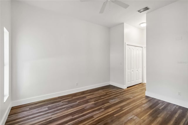 spare room featuring ceiling fan and dark wood-type flooring