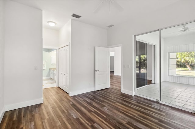 unfurnished bedroom with a closet, ceiling fan, dark hardwood / wood-style flooring, and ensuite bathroom