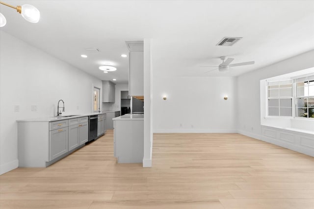 kitchen featuring gray cabinetry, ceiling fan, sink, black dishwasher, and light wood-type flooring