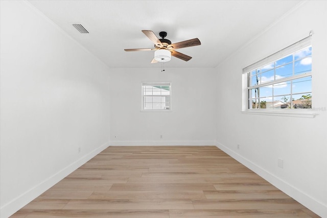 spare room featuring light hardwood / wood-style floors, ceiling fan, and a healthy amount of sunlight