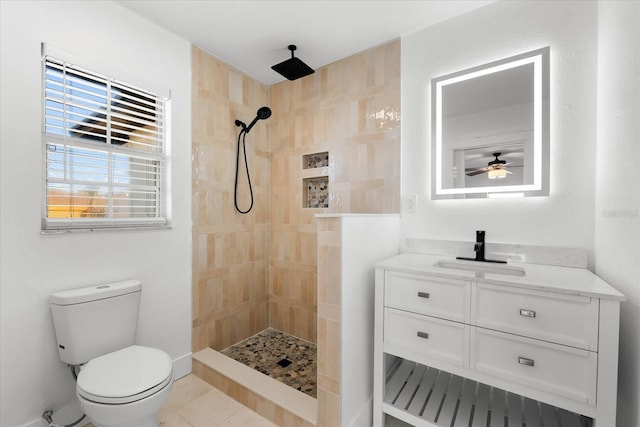 bathroom featuring ceiling fan, toilet, a tile shower, and vanity