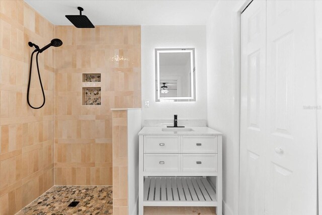 bathroom featuring a tile shower and vanity