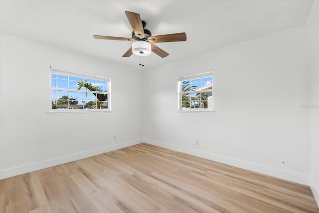 spare room featuring ceiling fan, light hardwood / wood-style flooring, and a healthy amount of sunlight