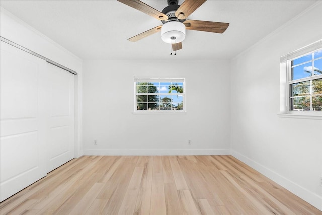 unfurnished bedroom with light wood-type flooring, a closet, ornamental molding, and ceiling fan