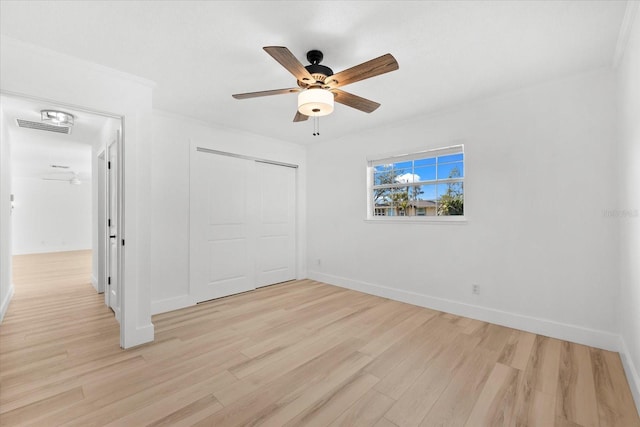 unfurnished bedroom featuring a closet, crown molding, ceiling fan, and light hardwood / wood-style floors