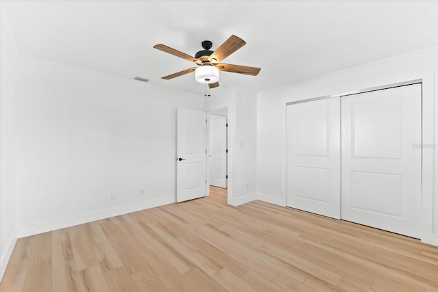 unfurnished bedroom featuring ceiling fan, a closet, and light hardwood / wood-style floors