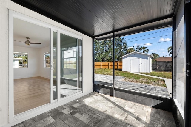 unfurnished sunroom featuring ceiling fan and wooden ceiling