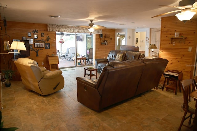 living room featuring wooden walls and ceiling fan