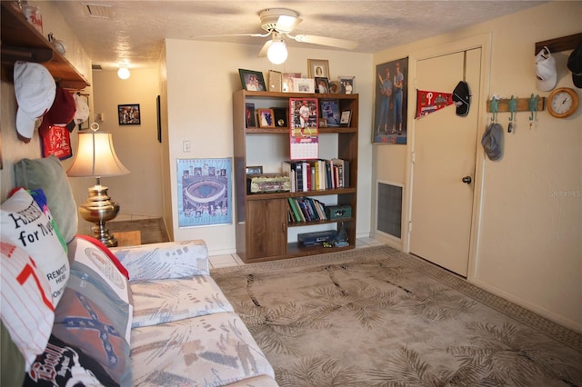 sitting room featuring ceiling fan and a textured ceiling