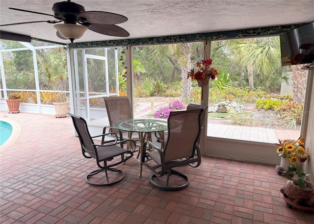 sunroom / solarium featuring ceiling fan