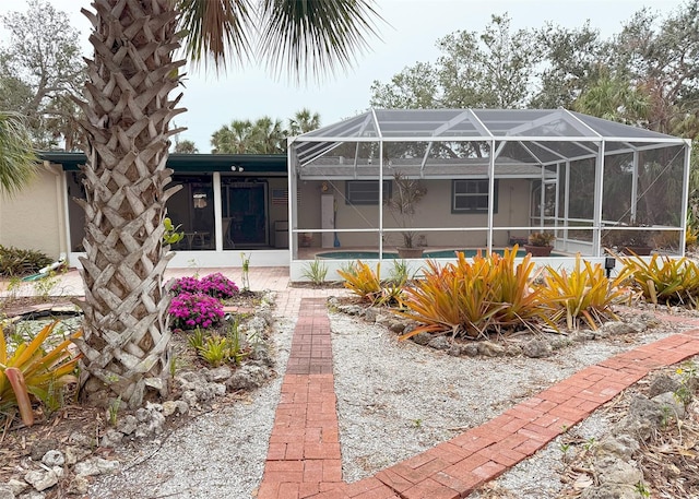 rear view of house featuring glass enclosure