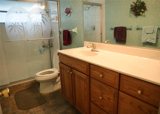 bathroom featuring vanity, toilet, and an enclosed shower