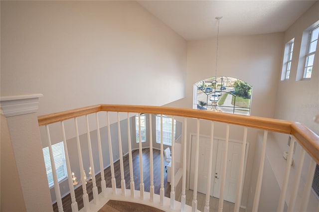 staircase with hardwood / wood-style flooring and an inviting chandelier