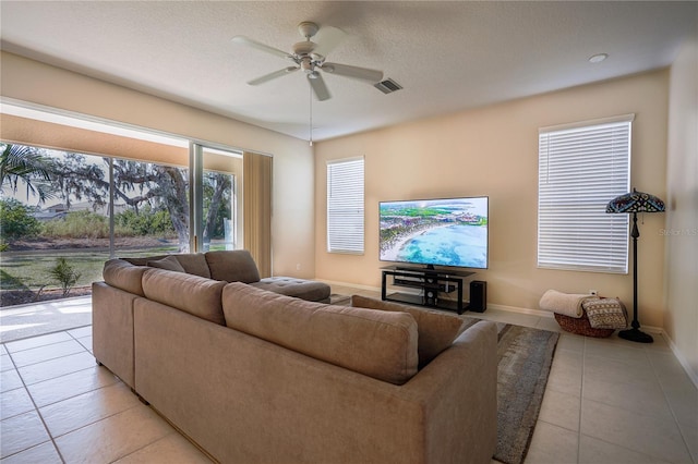 tiled living room with a textured ceiling and ceiling fan