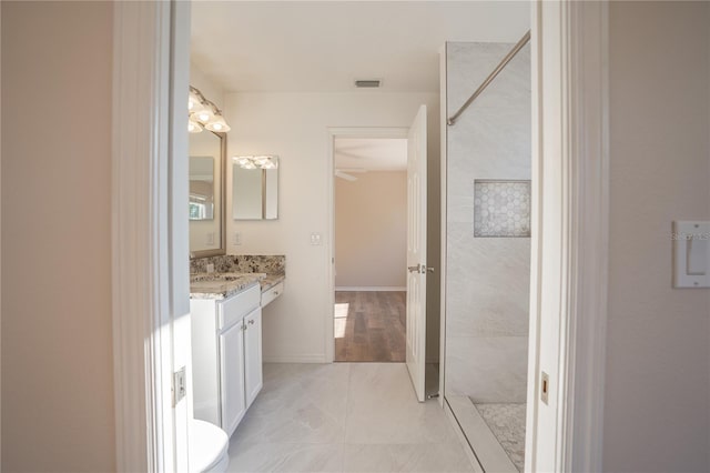 bathroom featuring vanity and tiled shower