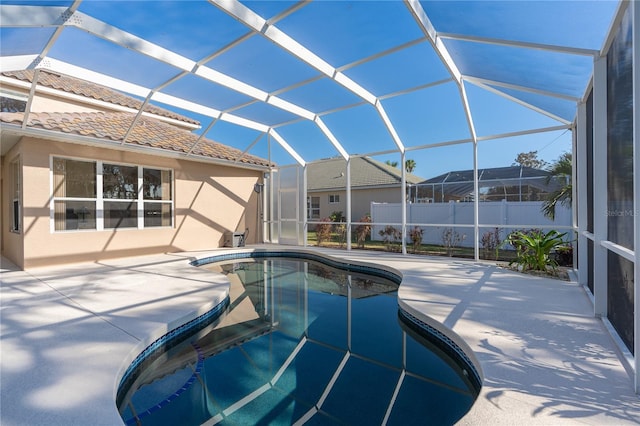 view of pool with glass enclosure and a patio area