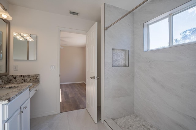 bathroom with vanity and tiled shower