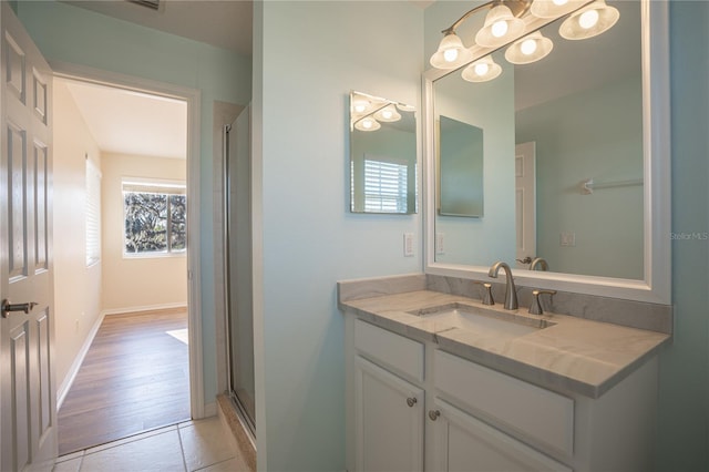 bathroom with tile patterned floors, vanity, a healthy amount of sunlight, and walk in shower