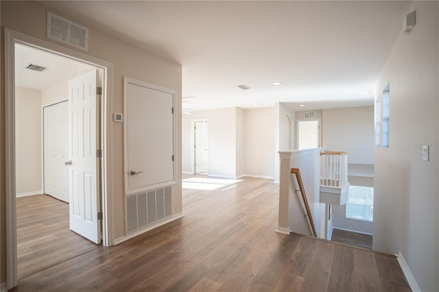 hall with a healthy amount of sunlight and wood-type flooring