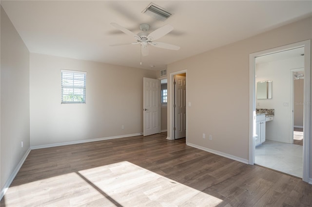 unfurnished bedroom featuring ensuite bath, ceiling fan, and wood-type flooring