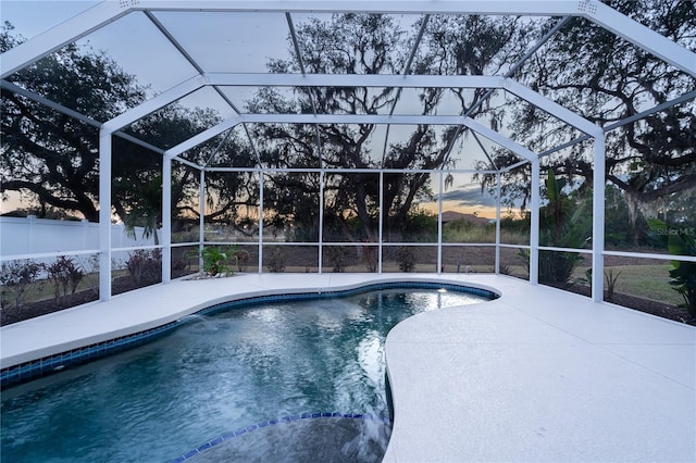 pool at dusk featuring a patio area and a lanai