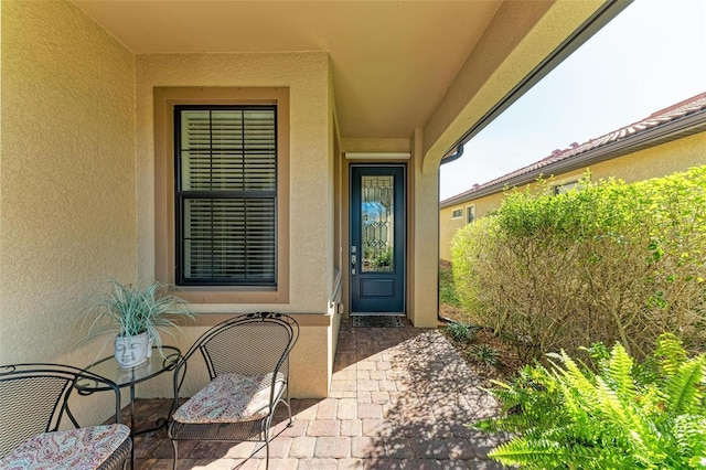 view of exterior entry with a patio