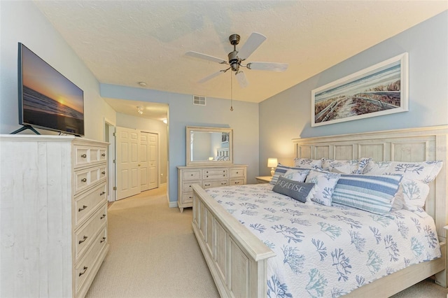 carpeted bedroom featuring ceiling fan, a closet, and a textured ceiling