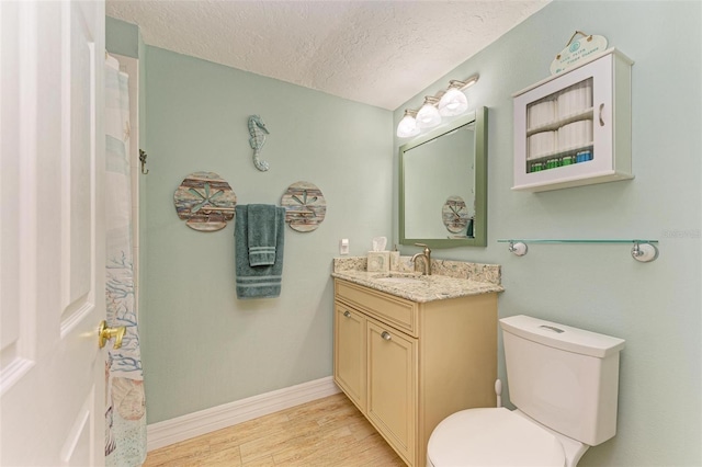 bathroom featuring a textured ceiling, toilet, vanity, and hardwood / wood-style floors