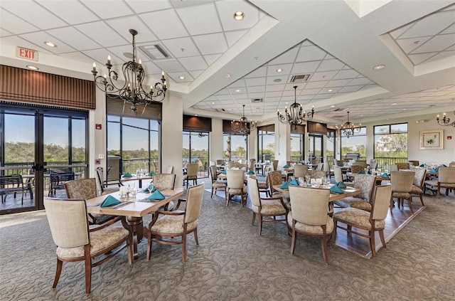 carpeted dining area with a drop ceiling