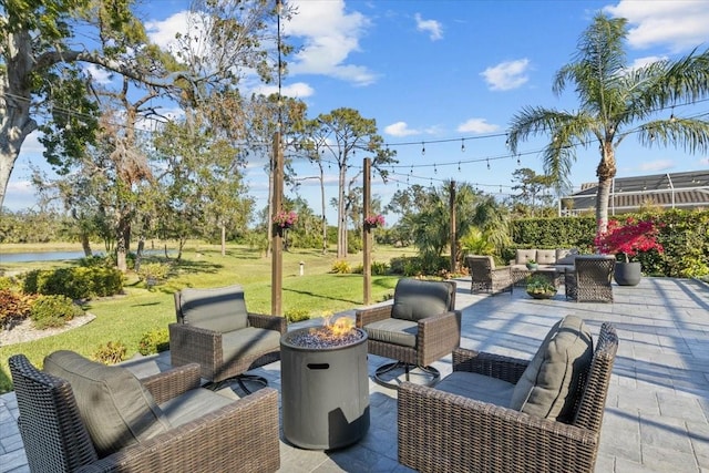 view of patio featuring a water view and an outdoor living space with a fire pit