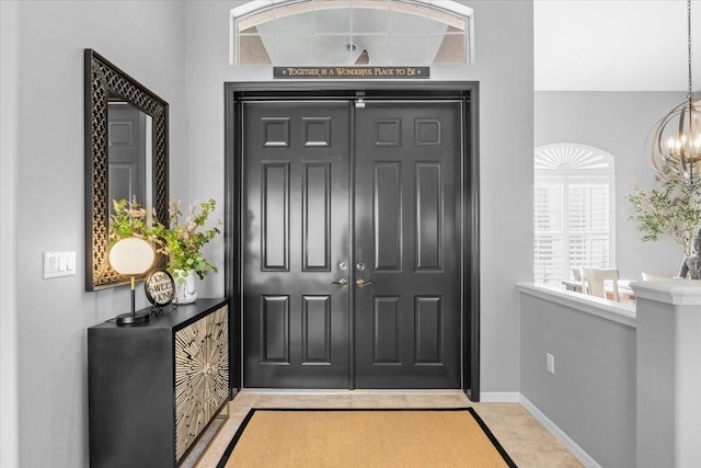 foyer entrance with light tile patterned flooring and a chandelier