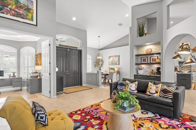 tiled living room featuring high vaulted ceiling and a notable chandelier