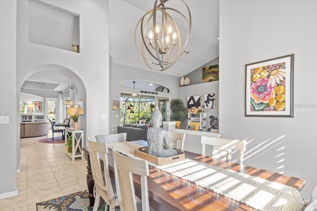 tiled dining space featuring high vaulted ceiling and an inviting chandelier