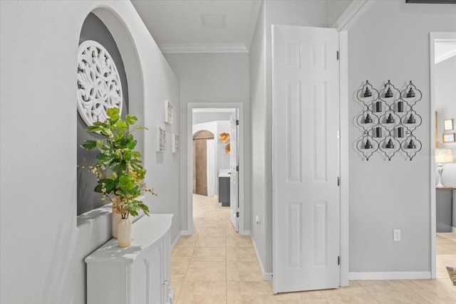 corridor with light tile patterned floors and crown molding