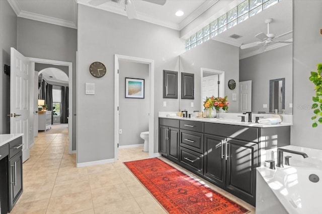 bathroom with vanity, tile patterned floors, crown molding, ceiling fan, and a towering ceiling