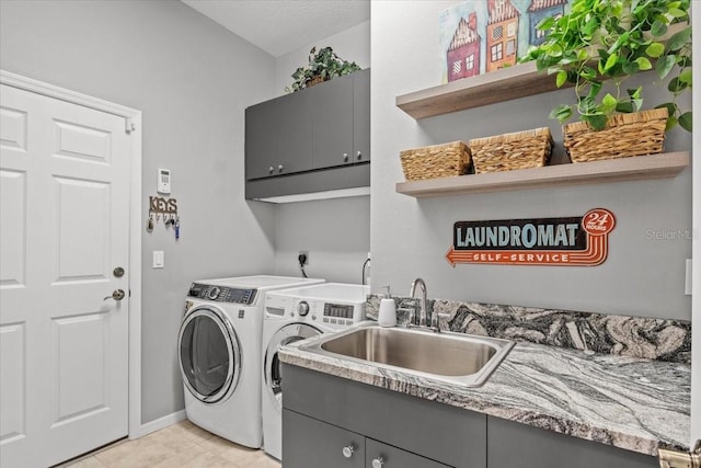 clothes washing area with sink, light tile patterned flooring, cabinets, and independent washer and dryer