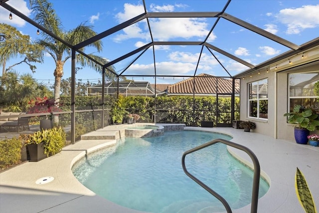 view of swimming pool with glass enclosure, a patio area, and an in ground hot tub