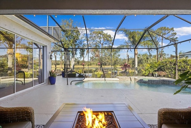 view of swimming pool with an in ground hot tub, glass enclosure, an outdoor fire pit, and a patio area