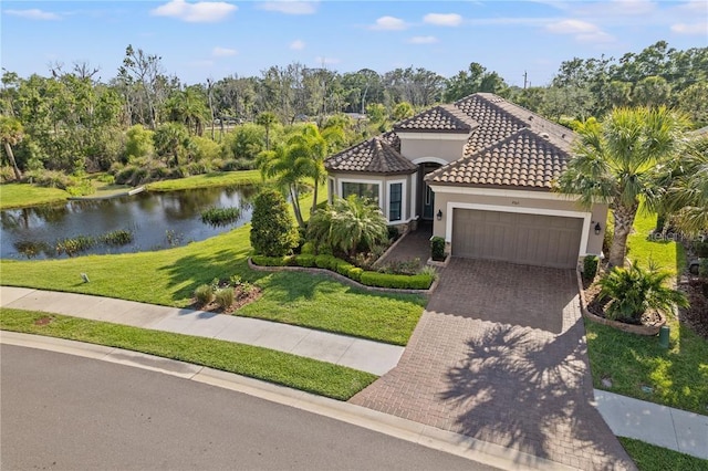 mediterranean / spanish-style house featuring a front yard, a garage, and a water view