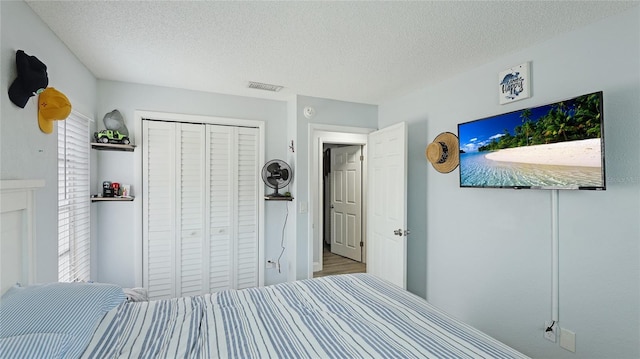 bedroom with a textured ceiling and a closet