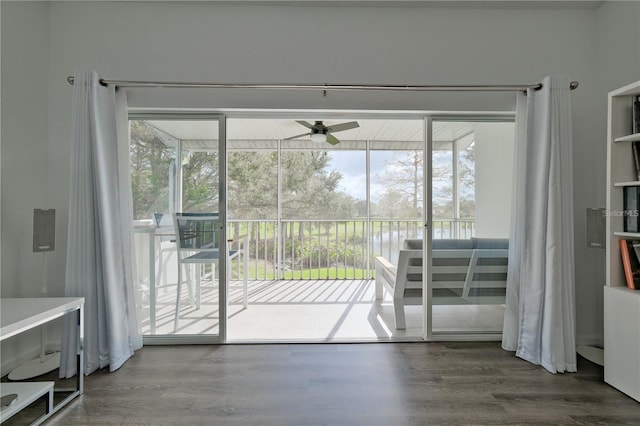 entryway with ceiling fan, a water view, and hardwood / wood-style flooring