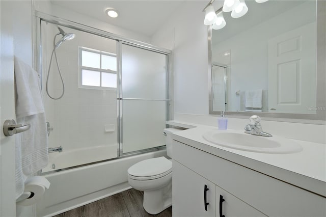 full bathroom with wood-type flooring, vanity, toilet, and enclosed tub / shower combo