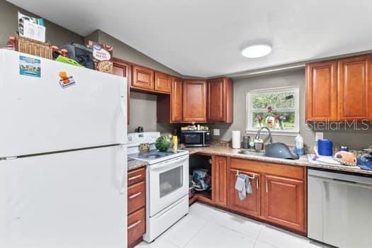 kitchen with light tile patterned floors, sink, and appliances with stainless steel finishes